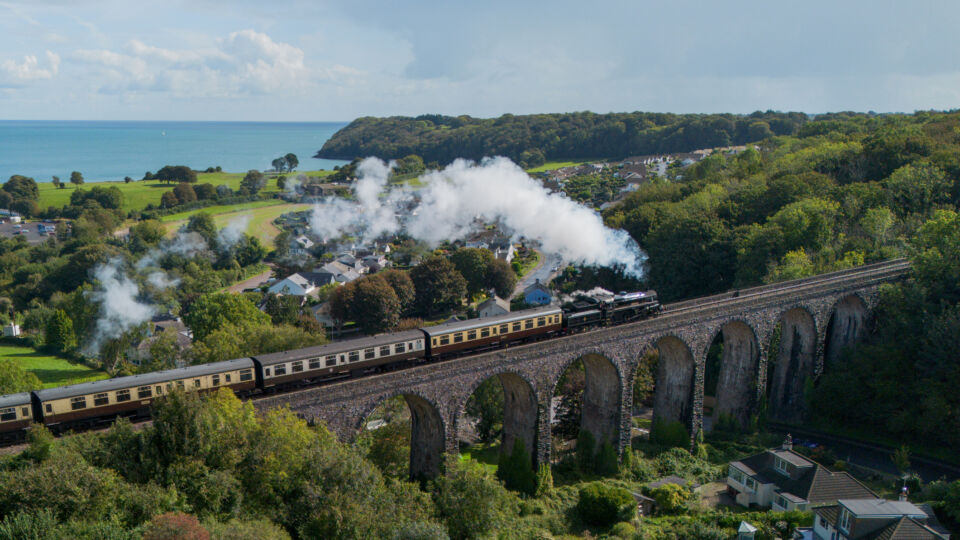 Old British Steam Train over the Viaduct by the sea in Devon